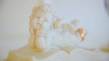 iki altın alyans. melek figürü heykelciği. melek kitap. portre