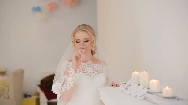 Невеста и жених позируют фотографу в студии возле камина с шампанским — стоковое видео