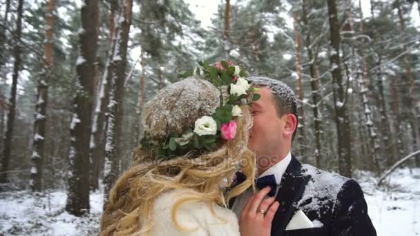 Jeune couple marchant dans la forêt d'hiver se tenant la main et embrassant au ralenti — Video