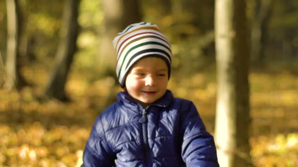 Portret van schattige kleine jongen draaien en draaien op zijn plaats. Slow motion — Stockvideo