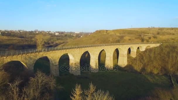 Plano aéreo del puente ferroviario de piedra al atardecer con interesante sombra 4k — Vídeos de Stock