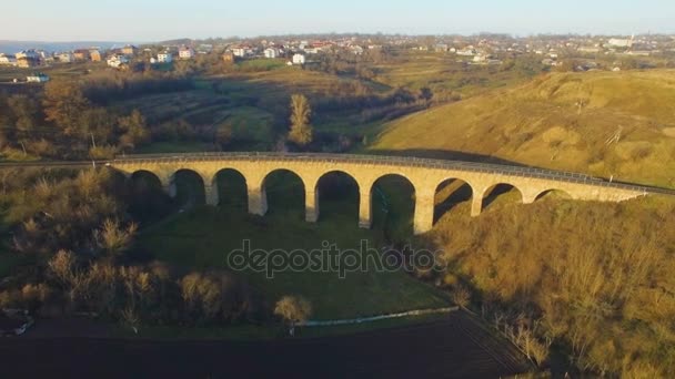 Plan aérien du pont ferroviaire en pierre au coucher du soleil avec ombre intéressante 4k — Video