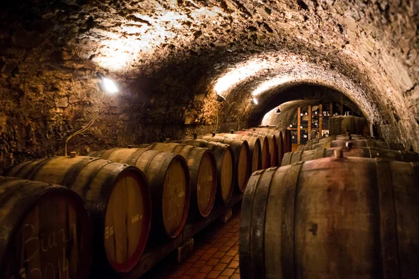 Old wooden barrels with wine in a wine vault, aged traditional w — Stock Photo, Image