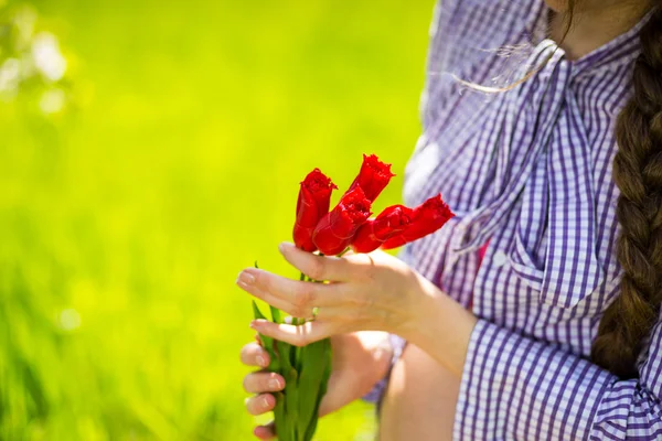 Беременность, тюльпаны в руках беременной девушки — стоковое фото