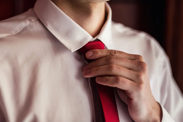 Concepto de personas, negocios, moda y ropa: primer plano del hombre con camisa vistiéndose y ajustando la corbata en el cuello en casa. Empresario poniéndose una corbata. Hombre poniéndose la corbata. Empresario vistiéndose por la mañana — Foto de Stock