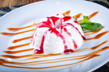 Cheesecake ile Ahududu sosu, lezzetli tatlı tatlı, yakın kadar ahşap arka plan