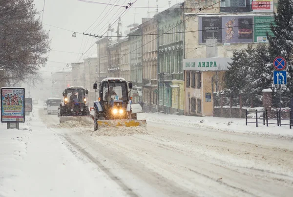 Lviv, Ucrania - 13 de noviembre de 2016: calle cubierta de nieve en Lviv. Máquinas de nieve calles limpias . — Foto de Stock