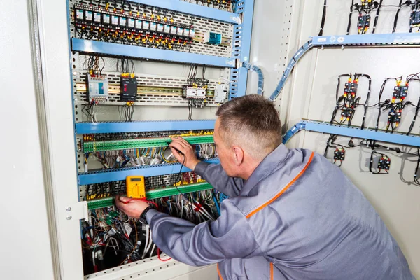 Elektricien industriële machine, elektricien bouwer ingenieur schroeven van apparatuur in de zekeringenkast, mannelijke elektricien testen — Stockfoto