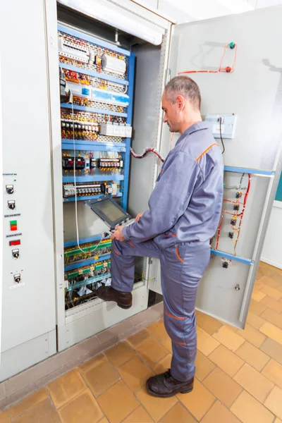 Elektricien industriële machine, elektricien bouwer ingenieur schroeven van apparatuur in de zekeringenkast, mannelijke elektricien testen — Stockfoto