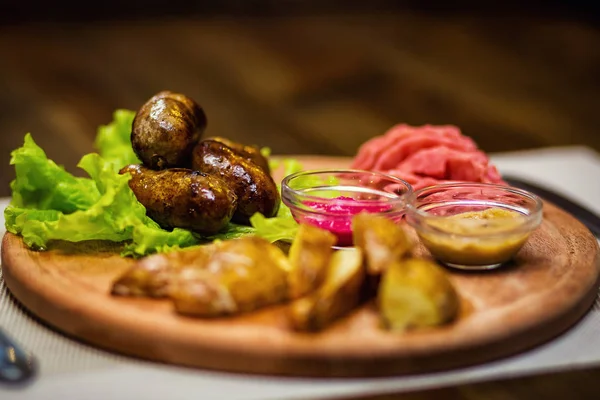 Parówki, kiełbaski smażone z ziemniakami, przekąski, piwo przekąski, sosy, musztarda, chrzan, restauracja, serwująca posiłki w restauracji — Zdjęcie stockowe