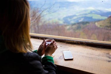 çay, Karpatlar, dağlar ısınma bir fincan çay, kız görünüyor pencereden dışarı, görünümü dağların penceresinden tutan kadın