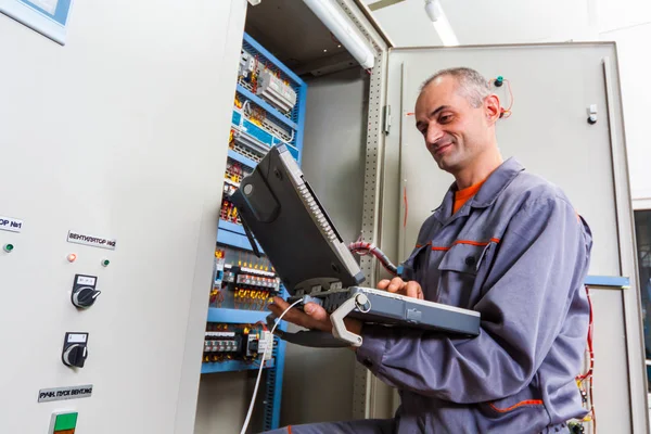 Eletricista máquina industrial de teste, engenheiro construtor eletricista aparafusar equipamentos na caixa de fusíveis, eletricista masculino, conservação de energia, trabalho elétrico, reparação de eletricista — Fotografia de Stock