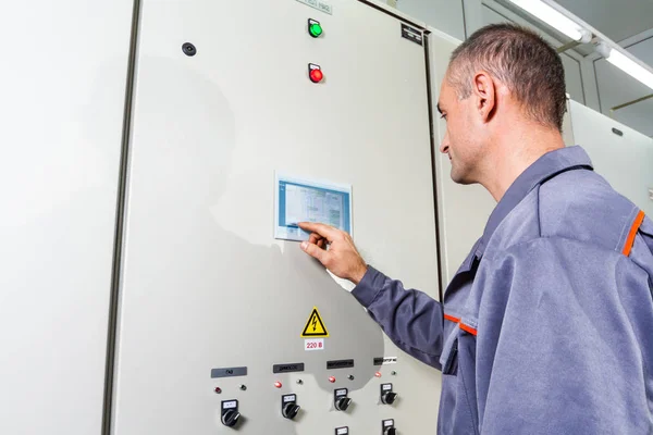electrician testing industrial machine, electrician builder engineer screwing equipment in fuse box, Male Electrician,energy conservation, electrical work, repair of electricit