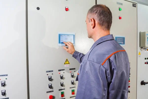 electrician testing industrial machine, electrician builder engineer screwing equipment in fuse box, Male Electrician,energy conservation, electrical work, repair of electricit