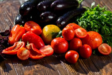 Taze, olgun domates, patlıcan, tatlı kırmızı biber ve maydanoz ahşap arka plan üzerinde Close-Up. Sebze grubu. Kırmızı ve sarı domates, biber, patlıcan ve su damlaları maydanoz 