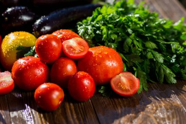 Taze, olgun domates, patlıcan, tatlı kırmızı biber ve maydanoz ahşap arka plan üzerinde Close-Up. Sebze grubu. Kırmızı ve sarı domates, biber, patlıcan ve su damlaları maydanoz 