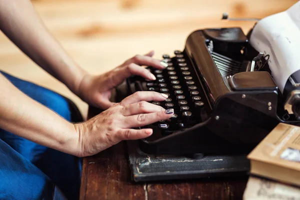 Woman typing on the typewriter, closeup. Fingers on the keys of a typewriter. Vintage typewriter