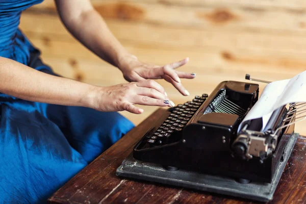 Woman typing on the typewriter, closeup. Fingers on the keys of a typewriter. Vintage typewriter