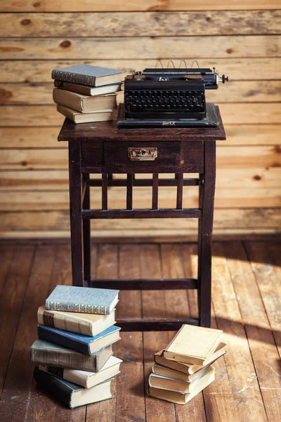 Máquina de escribir y libros sobre la mesa, máquina de escribir vintage y libros antiguos, vintage, área de escritor, máquina de escribir, máquina de escribir vieja con papel en blanco en escritorio de madera, llaves de máquina de escribir vieja, antigüedades, retro —  Fotos de Stock