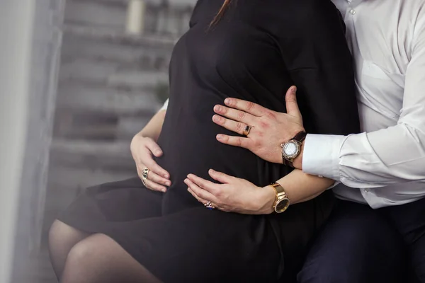 Foto de vientre de mujer embarazada. Las manos abrazando la barriga embarazada. Acercamiento de manos humanas sosteniendo la barriga embarazada. La mujer embarazada abraza su vientre. Embarazo. Concepto de embarazo —  Fotos de Stock