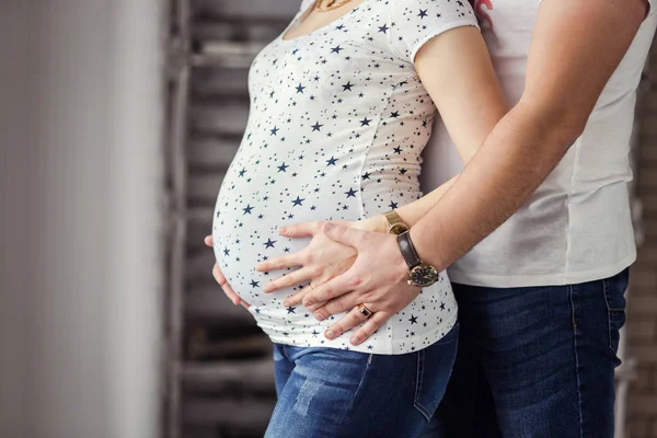 Photo of pregnant woman belly. Hands hugging pregnant belly. Close up of human hands holding pregnant belly. Pregnant woman hugs her belly. Pregnancy. Pregnancy Concept