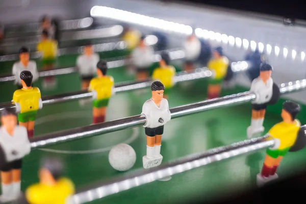 table football game, abstract light.Soccer table with Close up yellow and white players.Table football soccer game (kicker)