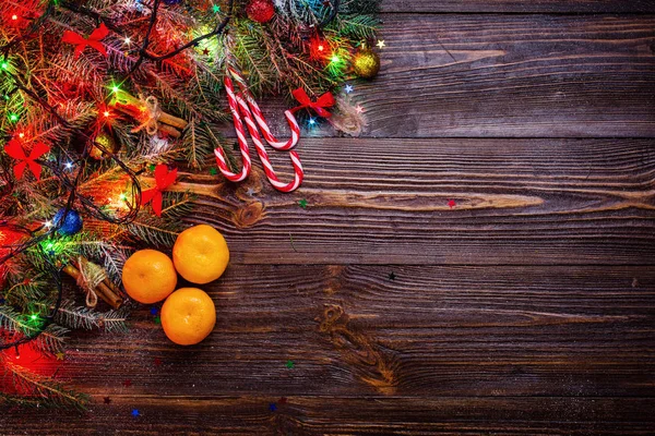 Fond en bois de Noël avec sapin des neiges. Vue avec espace de copie.Branche d'arbre de Noël avec décorations sur fond bois. Noël concept de vacances. Cadeaux de Noël, mandarines — Photo