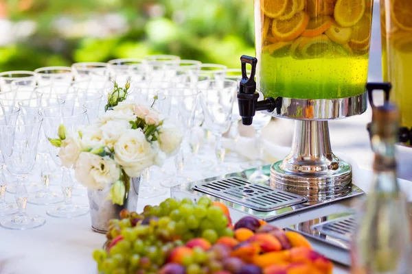 Fruity lemonade, fruit refreshing drink, orange juice, catering, glasses for wine or champagne,exit buffet, Lemonade in glass barrels — Stock Photo, Image