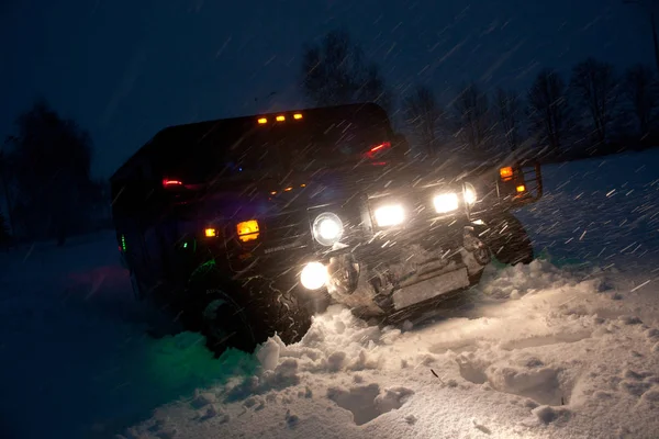 Vinnitsa, Ucrania 23 de febrero de 2012. Hummer H1 en ventisqueros, En la nieve, Negro americano fuera de la carretera, tuning, sesión de fotos del coche, un gran jeep fuera de la carretera — Foto de Stock