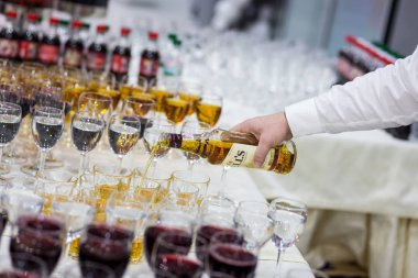 Garson şampanya cam içine dökülen. Boş bardak beyaz masada, bir dizi boş şampanya bardağı. Furshet, yemek tedarik. Şampanya veya şarap gözlük.