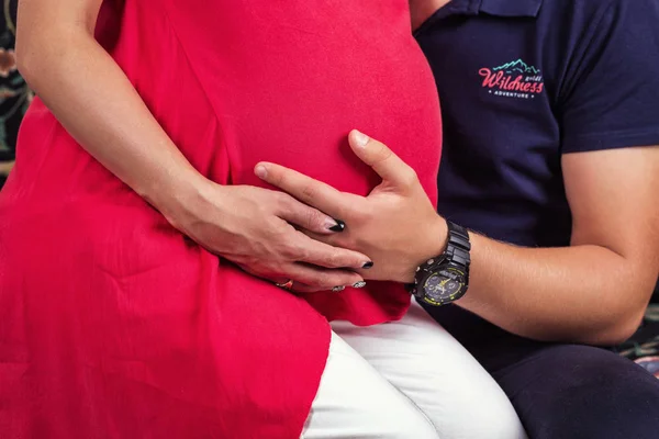 Foto de vientre de mujer embarazada. Las manos abrazando la barriga embarazada. Acercamiento de manos humanas sosteniendo la barriga embarazada. La mujer embarazada abraza su vientre. Embarazo. Concepto de embarazo —  Fotos de Stock