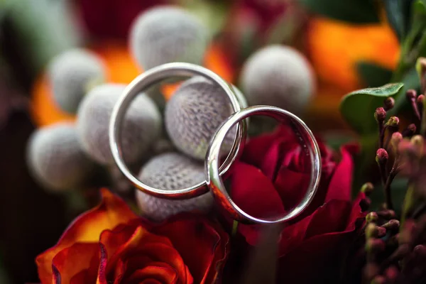 Βέρες βρίσκονται σε μια όμορφη γαμήλια ανθοδέσμη, γαμήλια δαχτυλίδια βρίσκονται σε ένα τριαντάφυλλα, Νυφικά Αξεσουάρ, Ευρωπαϊκής γάμος, αμερικανικός γάμος — Φωτογραφία Αρχείου
