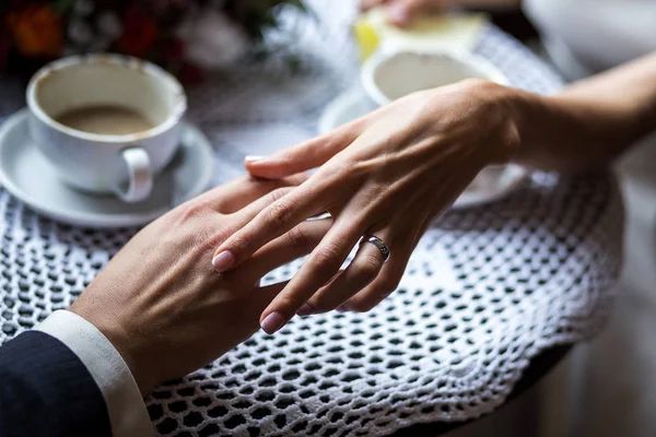 çift elele çift içme kahve bir kafede, sevgi dolu bir kafe, bir güzel buket, kahve çikolata şekerleme ile yakın çekim toplantıda eller