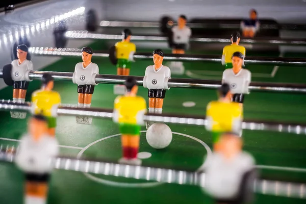 table football game, abstract light.Soccer table with Close up yellow and white players.Table football soccer game (kicker)