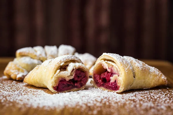 Kiraz ile lezzetli taze kruvasanlar ile pudra şekeri serpilir. Taze lapa lapa kruvasanlar, lezzetli kontinental kahvaltı croissants üzerinde kapatın. Taze ev yapımı croissants.croissant içinde — Stok fotoğraf