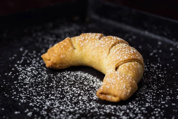 Chutné čerstvé croissanty, sypané moučkovým cukrem. Lahodné kontinentální snídaně s čerstvými croissanty šupinatá, Detailní záběr na croissants.croissant chleba na bufetové linky. Čerstvé domácí croissanty — Stock fotografie