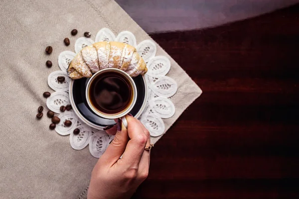 Delicioso café con croissant, una taza de café y croissants con granos de café y palitos de canela, desayuno con taza de café, croissants y chocolate — Foto de Stock