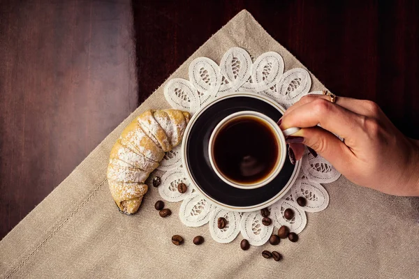 Délicieux café avec croissant, une tasse de café et croissants avec grains de café et bâtonnets de cannelle, petit déjeuner avec tasse de café, croissants et chocolat — Photo