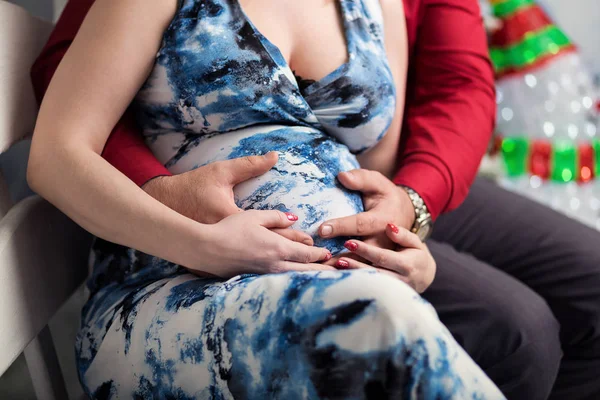 Photo of pregnant woman belly. Hands hugging pregnant belly. Close up of human hands holding pregnant belly. Pregnant woman hugs her belly. Pregnancy. Pregnancy Concept