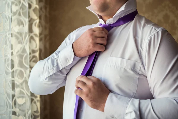 Concepto de personas, negocios, moda y ropa: primer plano del hombre con camisa vistiéndose y ajustando la corbata en el cuello en casa. Empresario poniéndose una corbata. Hombre poniéndose la corbata. Empresario vistiéndose por la mañana — Foto de Stock