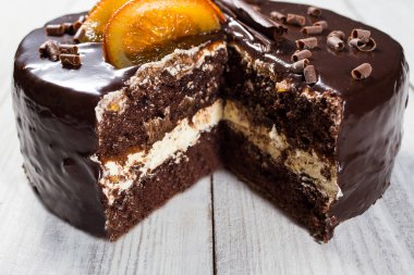 Şekerlenmiş portakal, bir kesme parça ve gri arka plan, portre, karanlık çikolatalı kek, lezzetli vejetaryen çikolatalı kek, lezzetli çikolatalı kek ahşap arka plan üzerinde bıçak ile çikolatalı kek ile çikolatalı kek