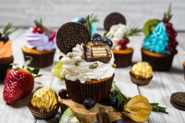 Çikolatalı kek. Cupcakes. Meyveler, meyve, çilek ile cupcakes. En çok view.colorful kek, lezzetli kek, renkli krem, ahşap arka plan üzerinde yaz meyveleri ile cupcakes, tatlı kavramı, kapatmak
