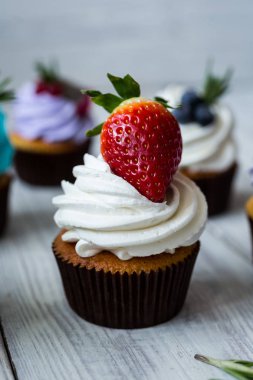 Çikolatalı kek. Cupcakes. Meyveler, meyve, çilek ile cupcakes. En çok view.colorful kek, lezzetli kek, renkli krem, ahşap arka plan üzerinde yaz meyveleri ile cupcakes, tatlı kavramı, kapatmak