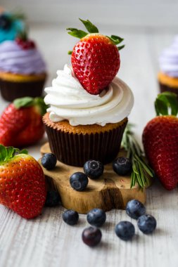 Çikolatalı kek. Cupcakes. Meyveler, meyve, çilek ile cupcakes. En çok view.colorful kek, lezzetli kek, renkli krem, ahşap arka plan üzerinde yaz meyveleri ile cupcakes, tatlı kavramı, kapatmak