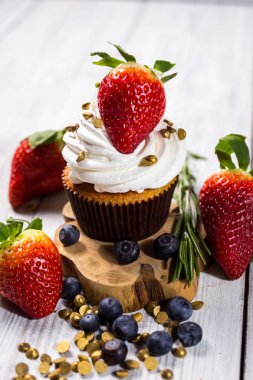 Çikolatalı kek. Cupcakes. Meyveler, meyve, çilek ile cupcakes. En çok view.colorful kek, lezzetli kek, renkli krema, şeker, ahşap arka plan üzerinde yaz meyveleri ile cupcakes, tatlı kavramı, kapatmak