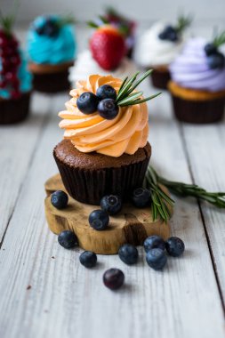 Çikolatalı kek. Cupcakes. Meyveler, meyve, çilek ile cupcakes. En çok view.colorful kek, lezzetli kek, renkli krem, ahşap arka plan üzerinde yaz meyveleri ile cupcakes, tatlı kavramı, kapatmak