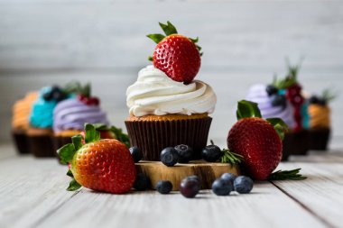 Çikolatalı kek. Cupcakes. Meyveler, meyve, çilek ile cupcakes. En çok view.colorful kek, lezzetli kek, renkli krem, ahşap arka plan üzerinde yaz meyveleri ile cupcakes, tatlı kavramı, kapatmak