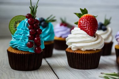 Çikolatalı kek. Cupcakes. Meyveler, meyve, çilek ile cupcakes. En çok view.colorful kek, lezzetli kek, renkli krem, ahşap arka plan üzerinde yaz meyveleri ile cupcakes, tatlı kavramı, kapatmak