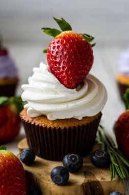 Çikolatalı kek. Cupcakes. Meyveler, meyve, çilek ile cupcakes. En çok view.colorful kek, lezzetli kek, renkli krema, şeker, ahşap arka plan üzerinde yaz meyveleri ile cupcakes, tatlı kavramı, kapatmak