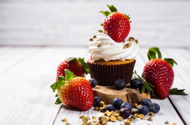 Çikolatalı kek. Cupcakes. Meyveler, meyve, çilek ile cupcakes. En çok view.colorful kek, lezzetli kek, renkli krema, şeker, ahşap arka plan üzerinde yaz meyveleri ile cupcakes, tatlı kavramı, kapatmak